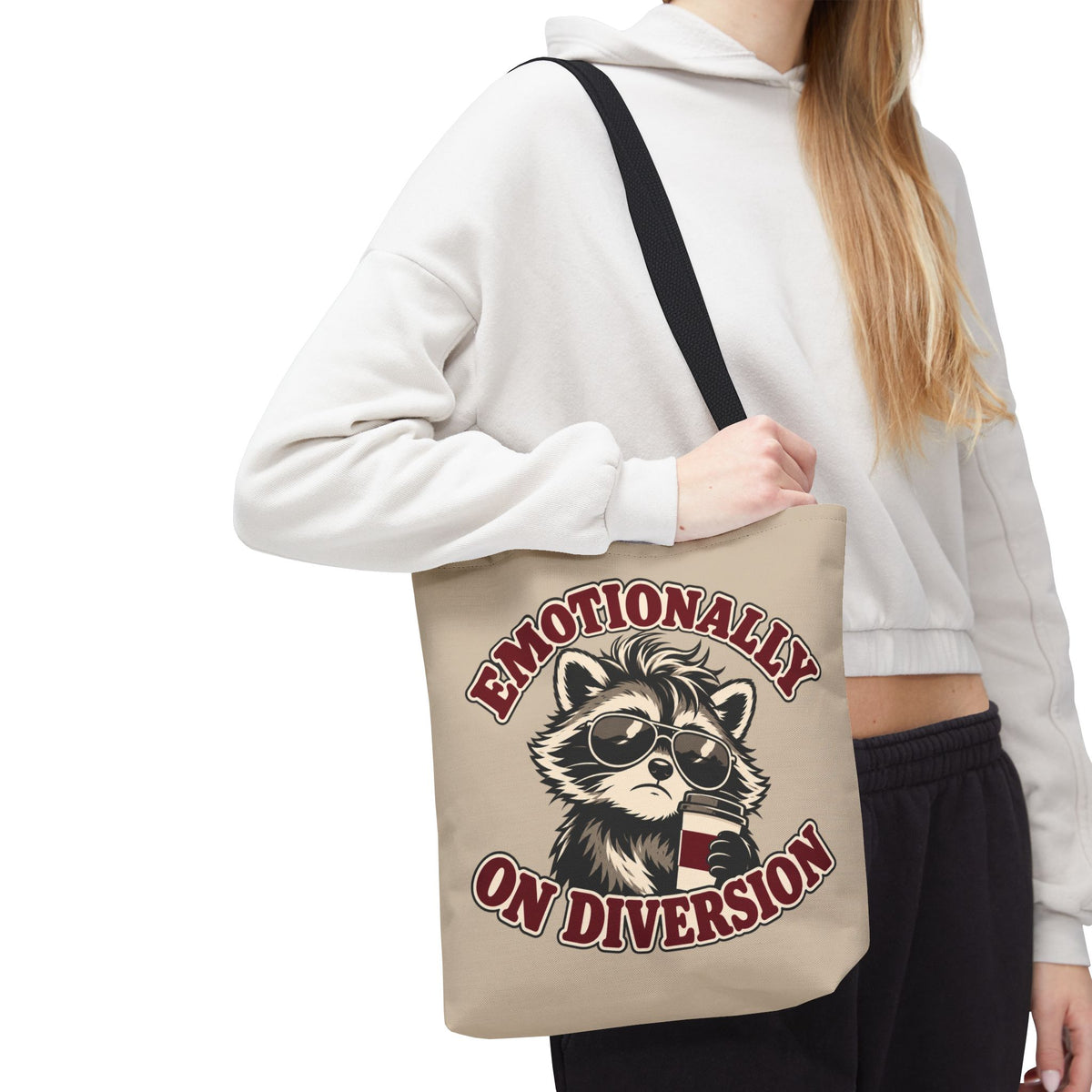 Emotionally on Diversion raccoon tote with Black handles, worn over a woman's shoulder
