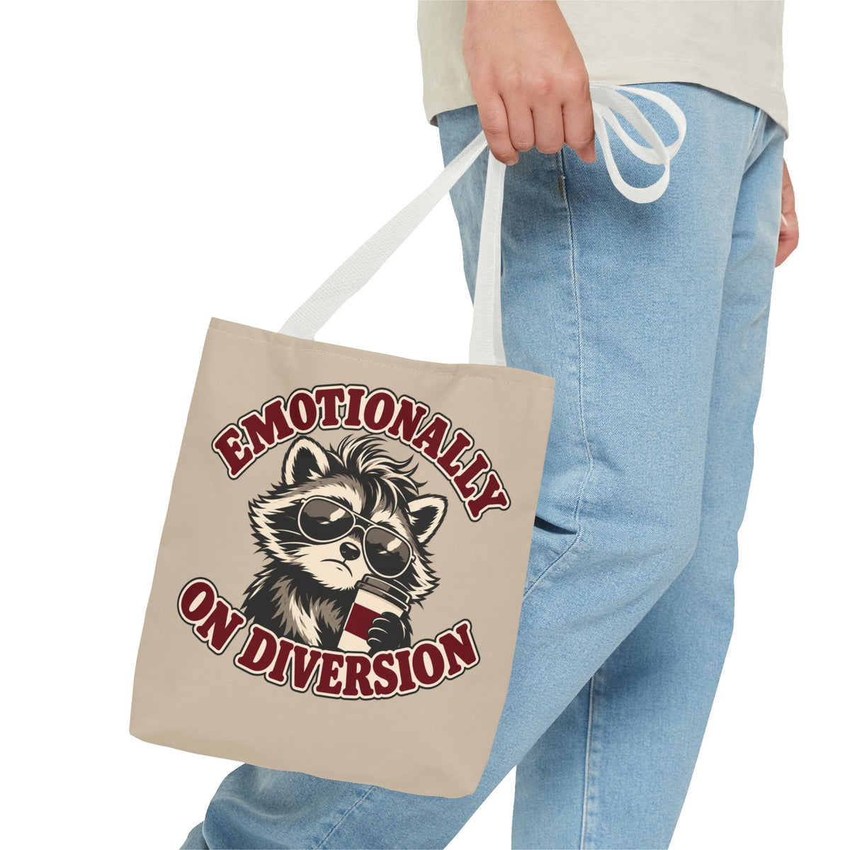 Emotionally on Diversion raccoon tote with White handles, carried by hand