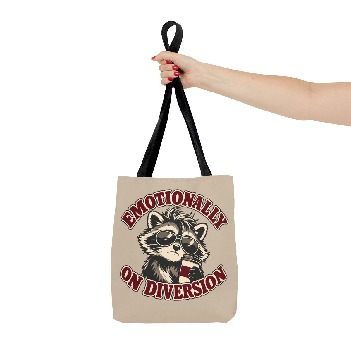 Emotionally on Diversion raccoon tote with Black handles, held on an arm