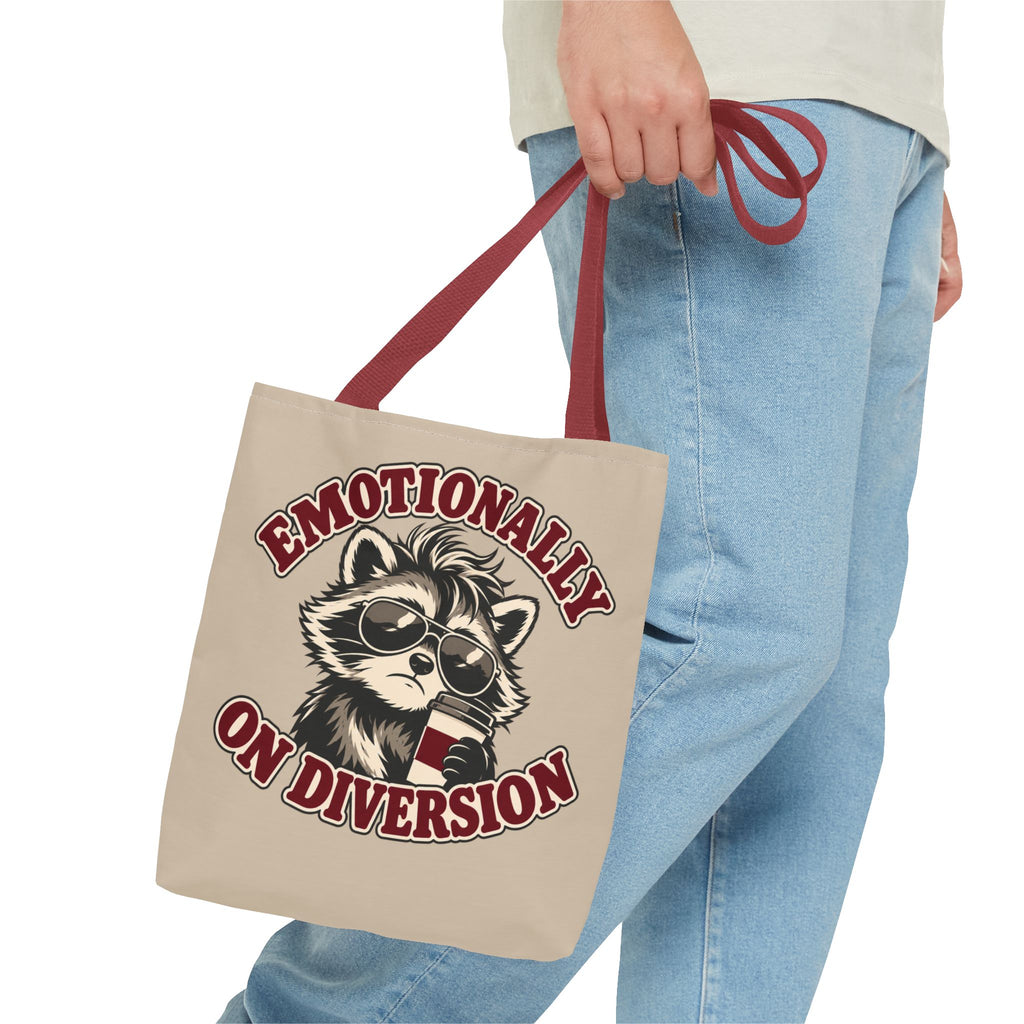 Emotionally on Diversion raccoon tote with Red handles, carried by hand