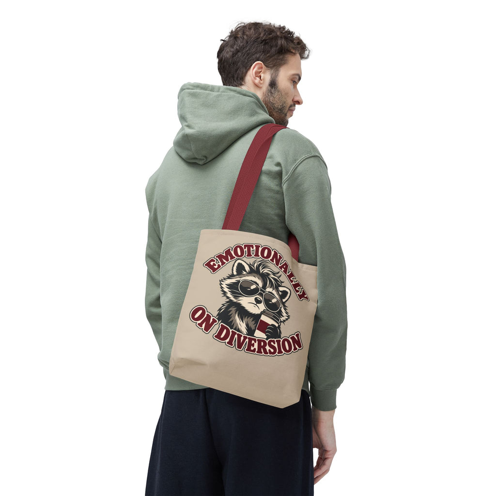 Emotionally on Diversion raccoon tote with Red handles, worn over a man's shoulder