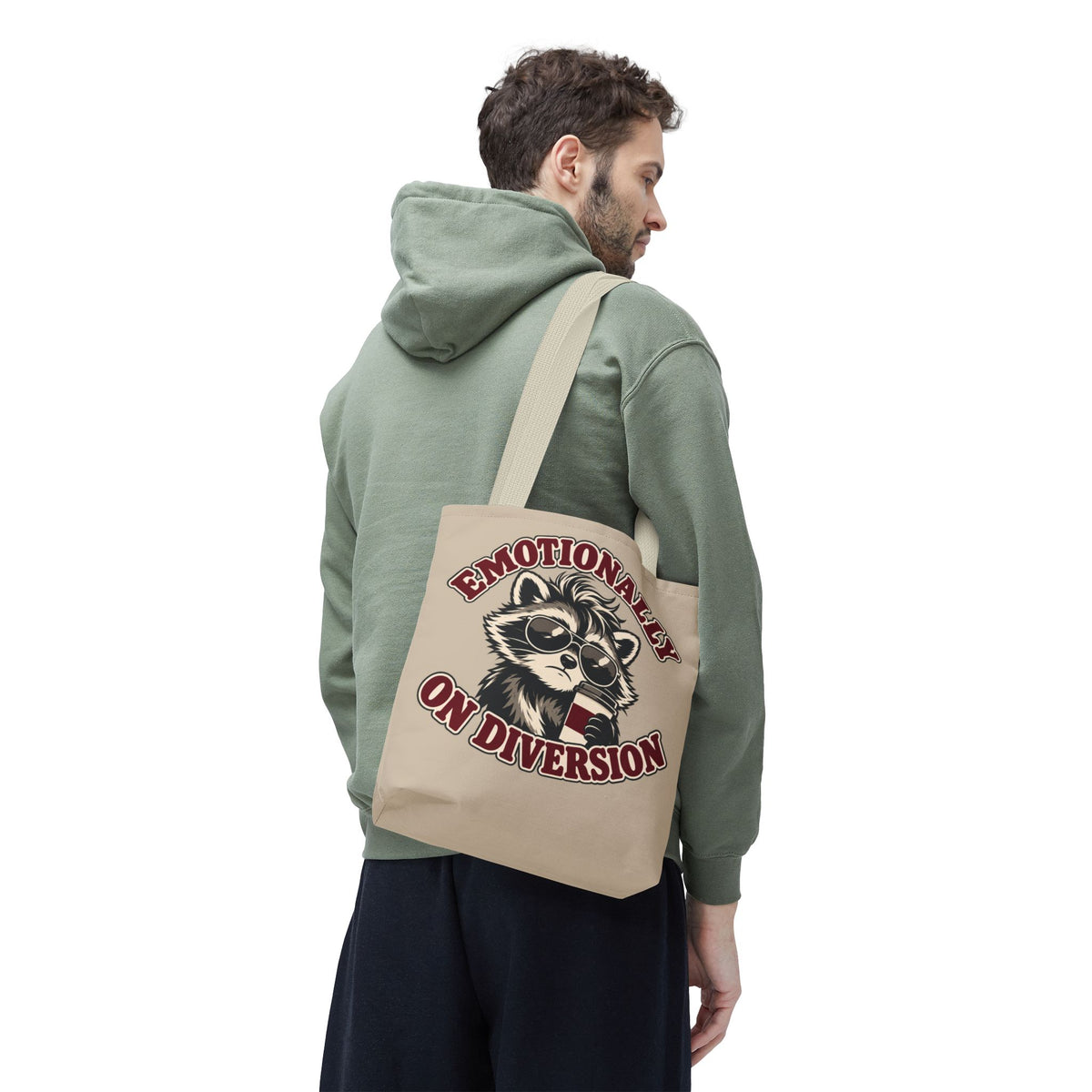 Emotionally on Diversion raccoon tote with Beige handles, worn over a man's shoulder