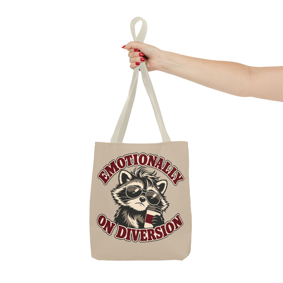 Emotionally on Diversion raccoon tote with Beige handles, held on an arm
