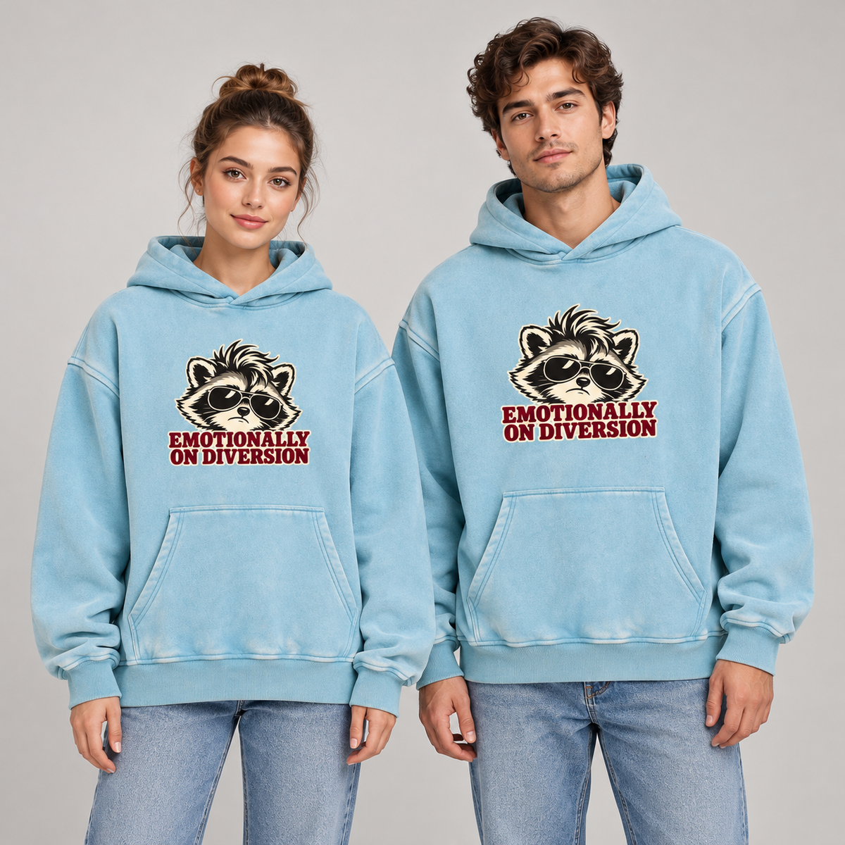 Man and woman wearing the Lake Blue Emotionally on Diversion oversized raccoon hoodie